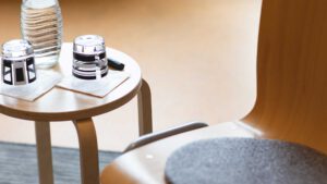 Kleiner Tisch mit zwei Gläsern neben einem Stuhl als Symbol für Konfliktbearbeitung und Mediation im Beruf